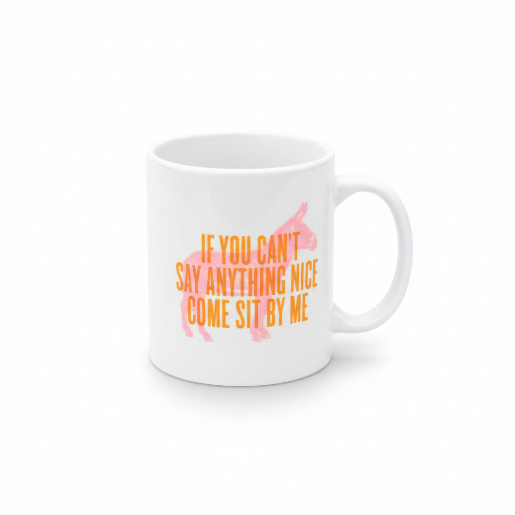 A white ceramic coffee mug with a pink donkey graphic and the text 'IF YOU CAN'T SAY ANYTHING NICE, COME SIT BY ME' in orange.