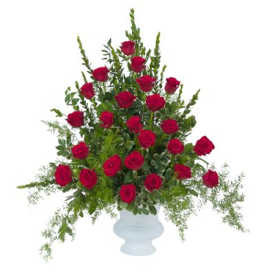 Sympathy / Funeral Arrangement of red roses with rich foliage, arranged in a white urn in traditional triangular garden style. Elegant and lush arrangement is a popular choice to send to funeral service or visitation 
