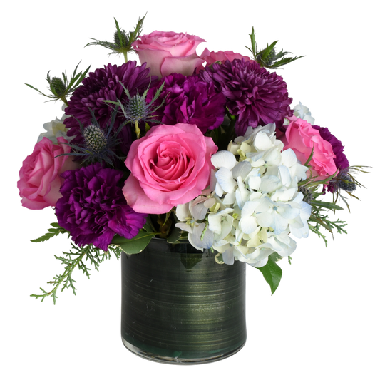 Jewel Queen Floral Arrangement where purple and plum flowers are accentuated with pink and touch of blue to create cheerful floral design.