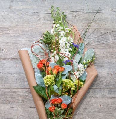 Market style bouquet of flowers wrapped in brown paper