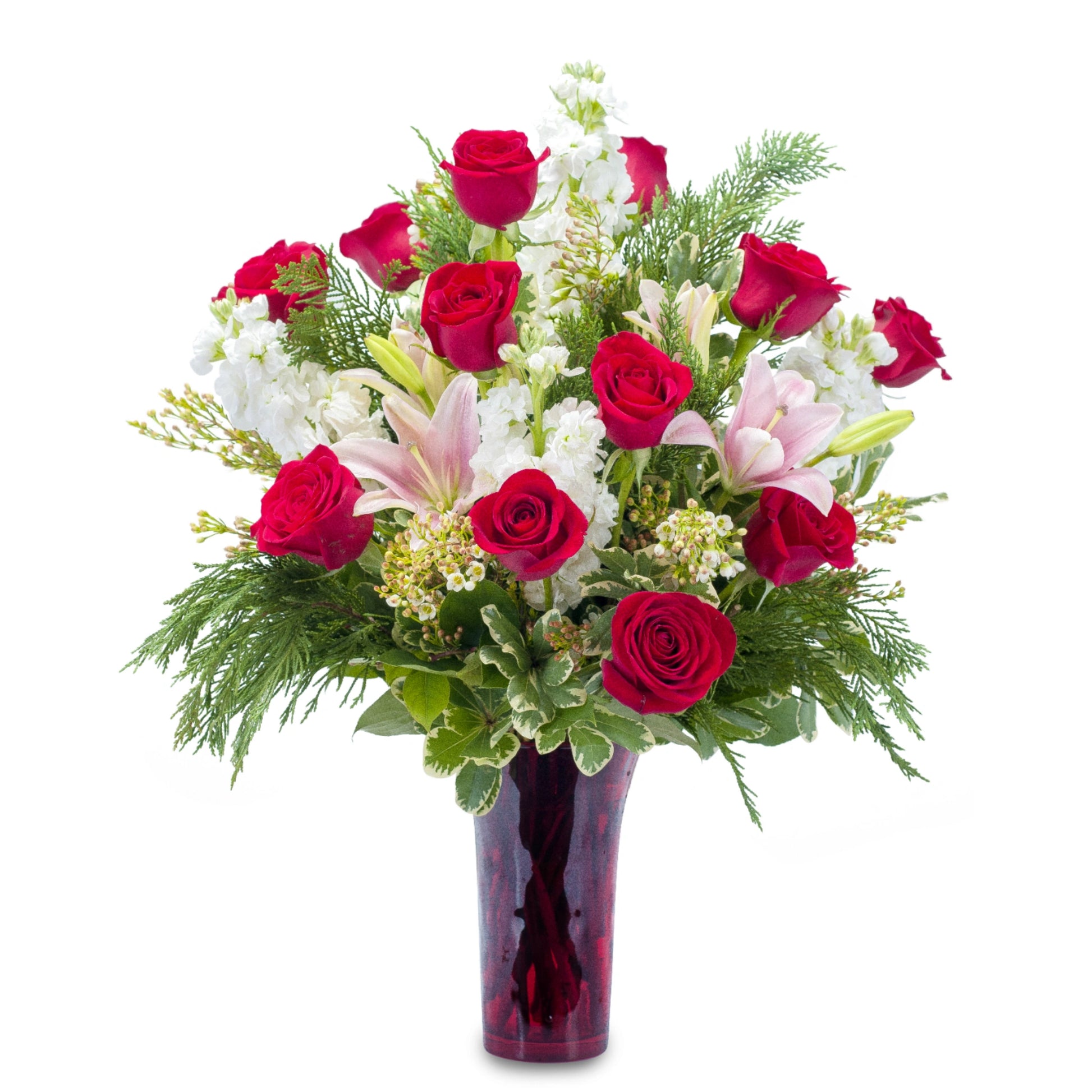 Seasonal Love Bouquet featuring lush combination of red roses and other pink and white flowers in a red vase